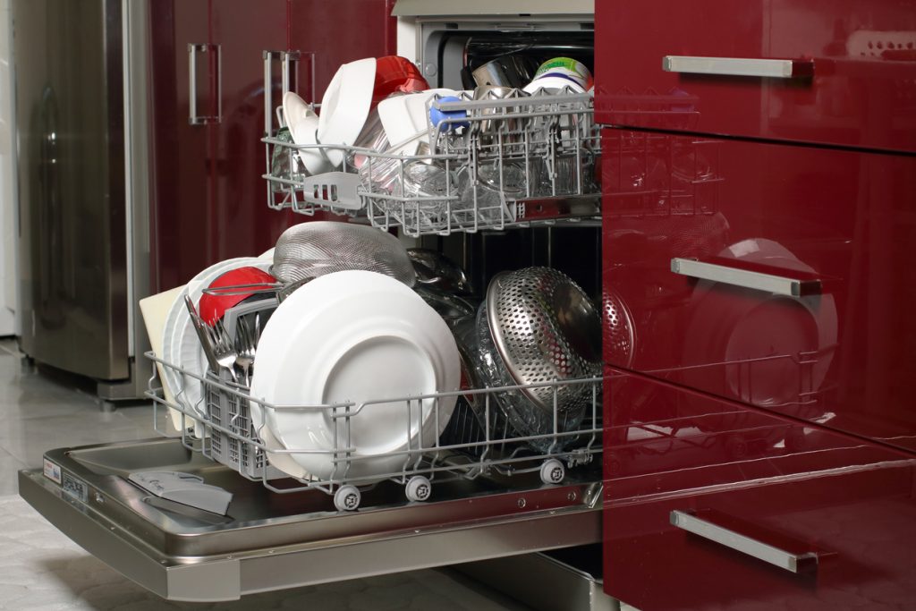 Dishwasher full with clean dishes in kitchen